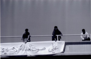 Women hanging a banner over an overpass in Iraq