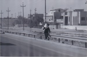 Woman in hijab walking along road in Iraq